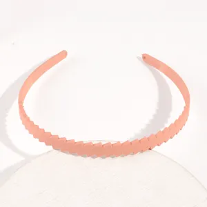 Primo piano del elegante cerchietto in plastica monocolore con motivo a blocchi obliqui.