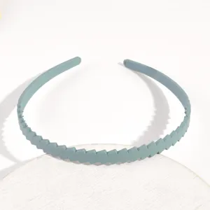 Vista dettagliata della fascia per capelli sottile in plastica zig-zag grigio-blu.