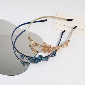 Vista detallada de elegantes diademas de pedrería con cuentas de cristal azul y champán.