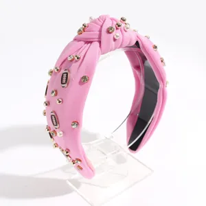 Pink knotted headband detail, featuring elegant pearls, rhinestones and football charms.