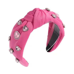 Serre-tête noué rose avec des strass en cœur scintillants pour un look adorable.