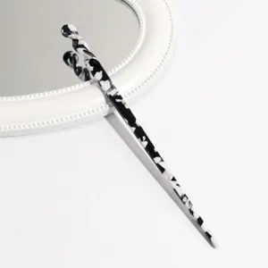 Black and white acetate hair stick detail, elegant leopard pattern hair accessory for elegant buns.