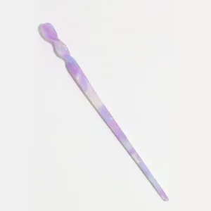Close-up detail of the purple gradient acetate hair stick, elegant twisted swirl design.