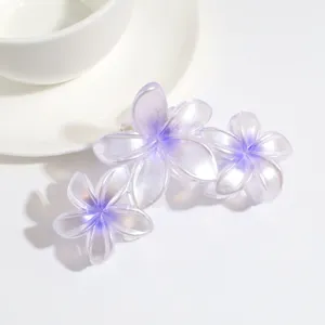 Primo piano dettagliato di una molletta per capelli a triplo fiore sfumato viola perlato.