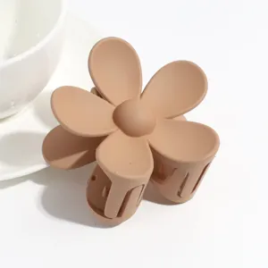Matte flower hair claw clip detail shot, elegant brown hair accessory for women daily styling.
