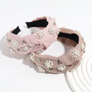 Detalle de diadema nudo perlas y estrás, accesorio de cabello de tela estilo vintage