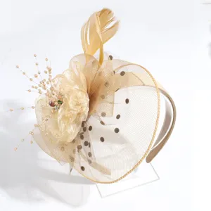 Detailed view of champagne fascinator headband with mesh, polka dots, feathers and floral detail.
