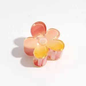 Detail view of the gradient flower hair claw clip, featuring translucent pink and yellow petals.
