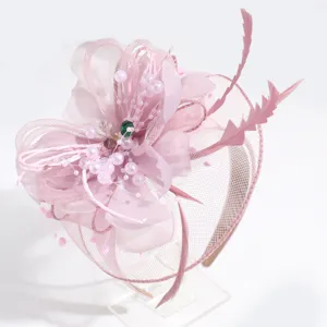 Detailed view of the pink feather fascinator headband with mesh, pearls, and delicate floral design.