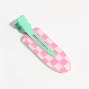 Detail shot of the cute pink and green checkered duckbill hair clip, showing the glossy texture and metal clasp.