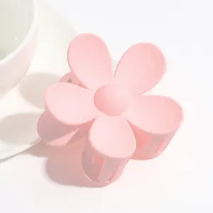 Detail view of the cute matte pink floral claw clip, highlighting its smooth frosted finish.
