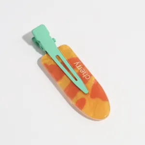 Detail view of sweet summer fruit juice style acrylic duckbill hair clip with mint green clip.