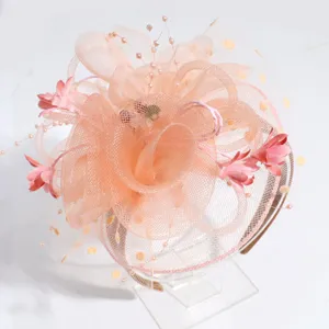 Detail view of elegant peach fascinator headband with mesh, flowers, and delicate pearls.