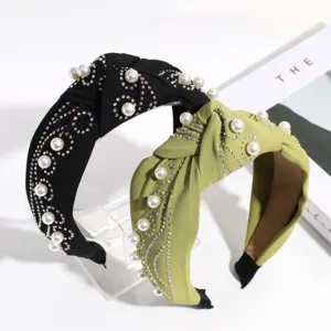 Vista detallada de diadema nudo perlas sintéticas y pedrería, accesorio de moda elegante.