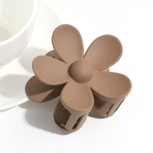 Matte brown flower hair claw clip, detailed close-up shot of cute hair accessory.