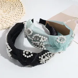 Primer plano de diademas vintage con perlas sintéticas y nudos en negro y verde menta.