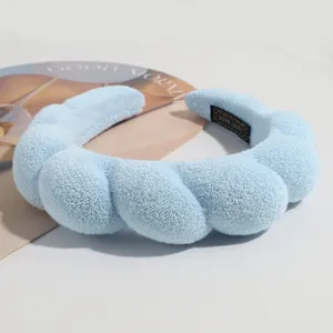 Close-up van lichtblauwe pluche wolk haarband, zacht gevlochten ontwerp voor dagelijkse styling.