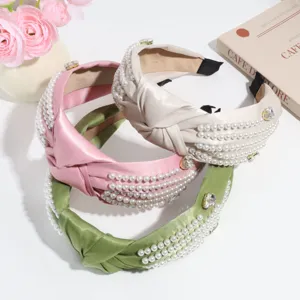 Wide knotted headband with pearls and rhinestones, elegant solid color hair accessory.
