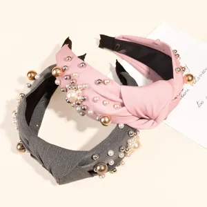 Primer plano de diademas nudo vintage decoradas con perlas de imitación y cuentas metálicas.