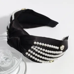 Elegant black satin knotted headband decorated with faux pearls and rhinestones for women.
