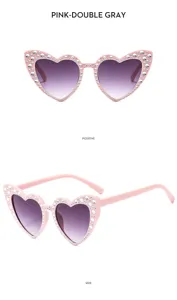 Gafas de sol infantiles corazón con estrás, montura rosa y lentes grises degradadas.