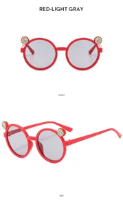 Close-up detail of red children sunglasses with cute rhinestone ear decor and grey lenses.
