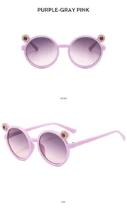 Close-up details of kids round sunglasses with rhinestone cat ears, pink purple gradient lens.