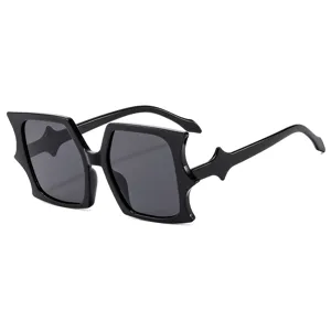 Trendy irregular bat shaped black frame sunglasses for women and men, avant garde style.
