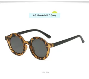 Gafas de sol redondas retro para niños con montura carey y lentes grises para aire libre.