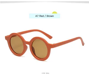Vista detallada de gafas de sol redondas retro para niños con montura naranja elegante.
