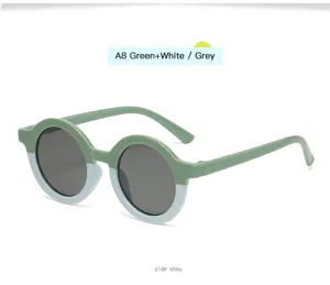 Vista de detalle gafas de sol infantiles redondas vintage, montura verde blanca y lentes.