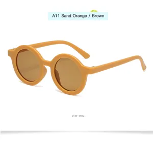 Vista detallada de gafas de sol infantiles redondas vintage, montura naranja arena.