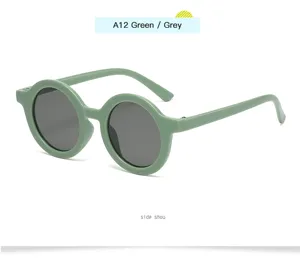 Gafas de sol redondas para niños con montura verde y lentes grises, diseño retro bonito.