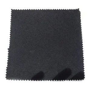 Primer plano detalle de muestra de tela negra con textura de borde en zigzag y calidad.