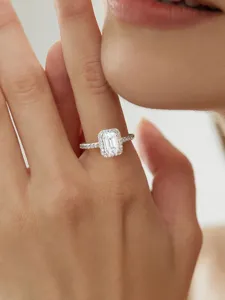 Nahaufnahme des Radiant-Schliff Moissaniten Rings mit filigranen Zirkoniasteinen in Silber.