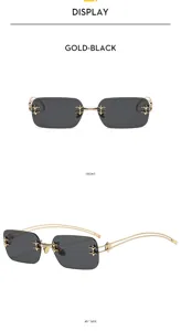 Vista detallada de gafas de sol punk sin montura con montura dorada y detalles de cruces.