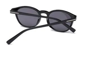 Stijlvolle vintage zwarte ronde zonnebril voor dames en heren, modieuze retro bril met metalen detail.