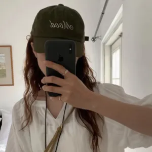 Detailed view of the dark green casual soft-top baseball cap with stylish mood embroidery.
