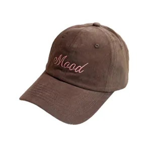 Detailed view of brown corduroy baseball cap featuring pink Mood embroidery lettering.