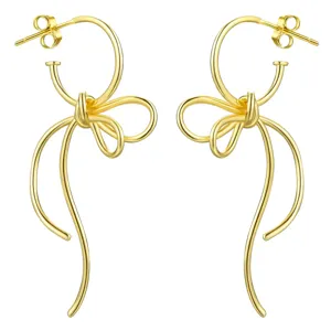 Détail en gros plan des boucles d'oreilles nœud créatives aux courbes élégantes et polies.