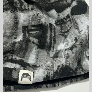 Close-up van de versleten tie-dye slouchy muts, met unieke grunge gebreide textuur en fijne details.