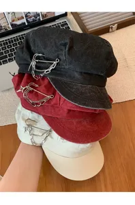 Close-up detail of retro octagonal hats with metal pin chain decoration, three colors.
