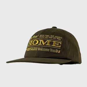 Detailed shot of the brown flat brim baseball cap with gold embroidery front design.