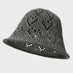 Close-up of dark gray hollow-out knit bucket hat showing breathable mesh texture details.