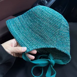 Fashionable mixed color knit bucket hat with side ties for summer sun protection.