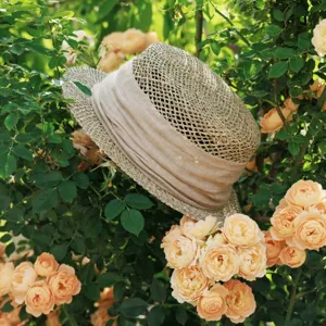 Exquisite detail view of French vintage hollow-out straw hat showing ribbon accents.