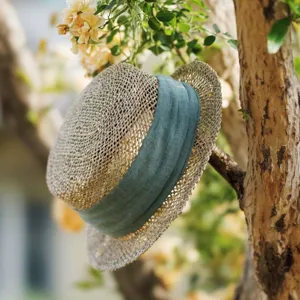 French retro woven straw hat detail, elegant green ribbon boater for summer beach sun.
