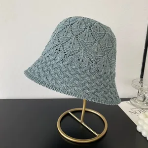 Detailed view of grey-blue mesh knit bucket hat, hollow diamond pattern, stylish spring sun hat.