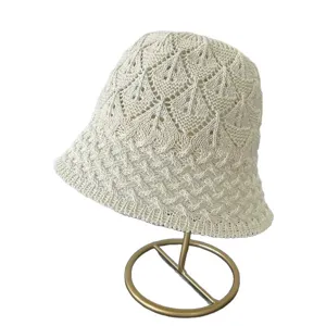 Chic cream white knitted bucket hat with mesh hollow design, perfect for spring and summer fashion.