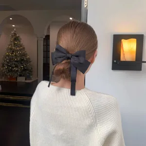 Elegant black bow hair clip with draping ribbon, perfect back of head spring hairpin.